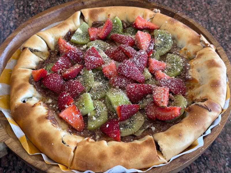 Nutella pizza dessert with strawberries and powdered sugar